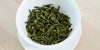 A top-down photo of brewed green tea leaves in a gaiwan.