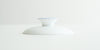 A white porcelain lid, with a blue ring around the top of the handle.