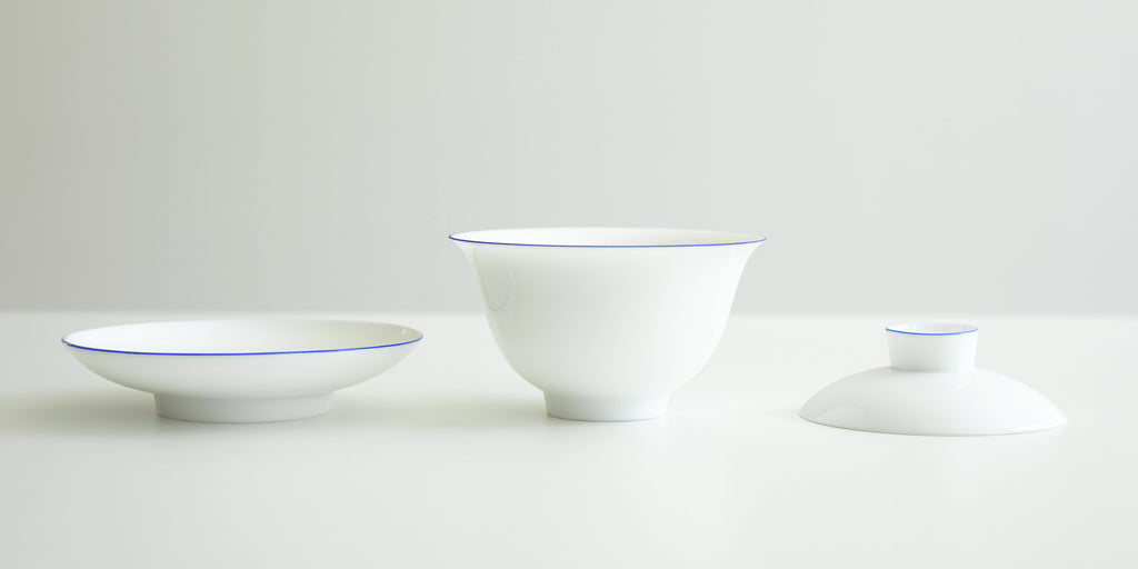 Side view of all the pieces for the gaiwan. From left to right, the plate, the bowl, and the lid