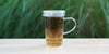 A glass cup with peppermint lavender brewing in the nested glass infuser.