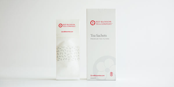 A pack of tea sachets displayed next to the box they come in.