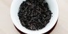 A top-down photo of brewed pu-erh tea leaves in a gaiwan.