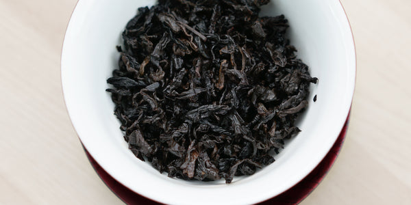 A top-down photo of brewed pu-erh tea leaves in a gaiwan.